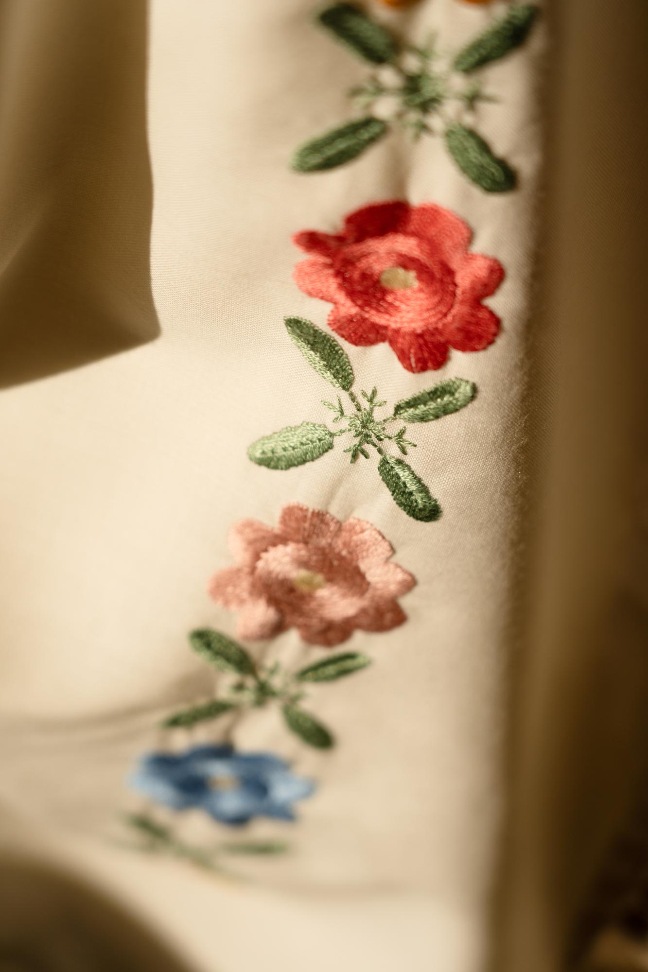 Nahaufnahme gestickter floraler Muster auf Leinen